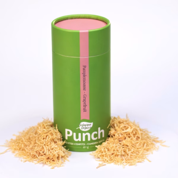 Tube de 40 g d'éclats de pamplemousse confits biologiques Punch posé sur un lit de zestes