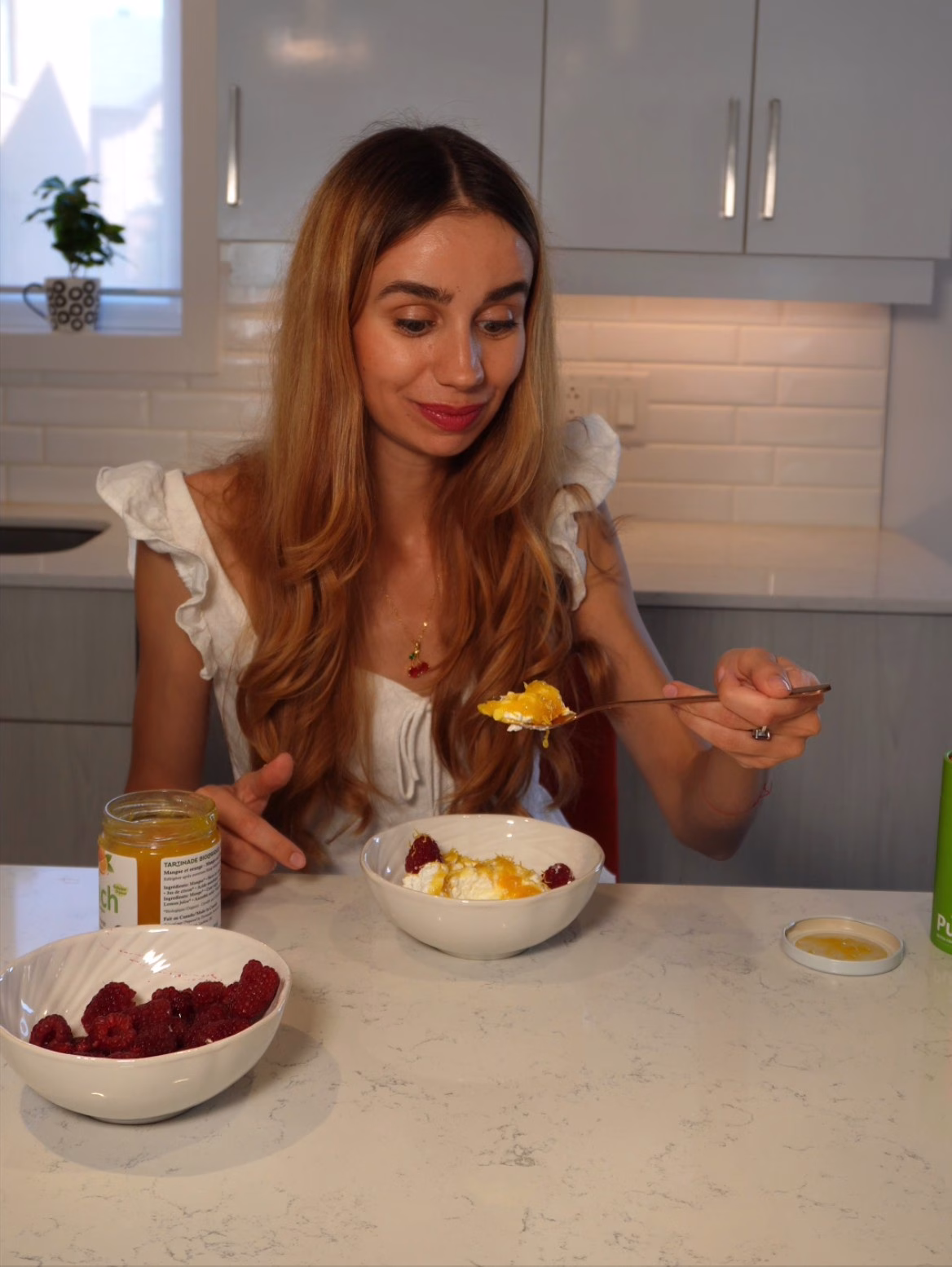 Julia se délecte d'un bol de fromage cottage avec tartinade mangue-orange et éclats d'orange.